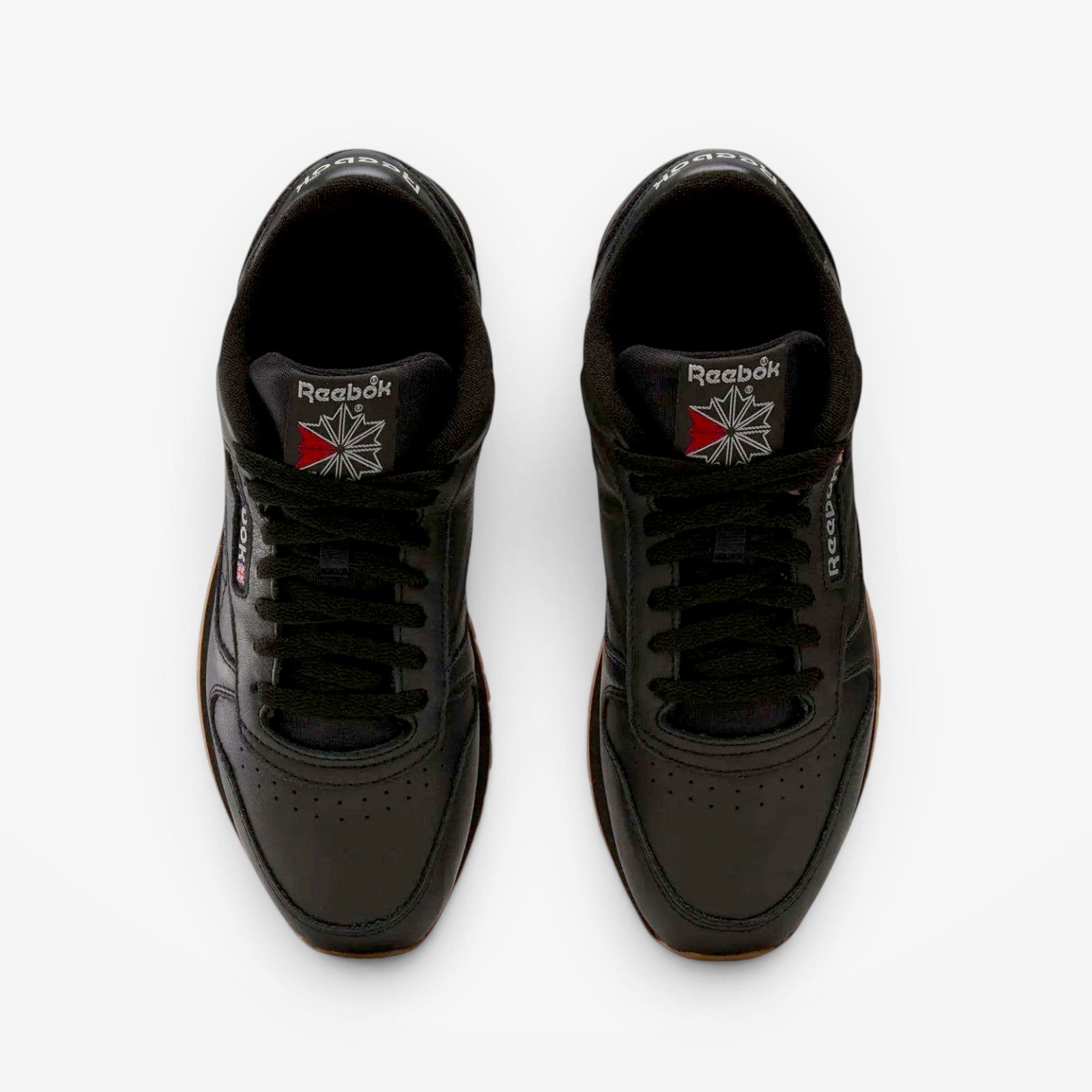 METRO Reebok Classic Leather black leather sneakers with grey accents and gum sole. Low-top lace-up style.
