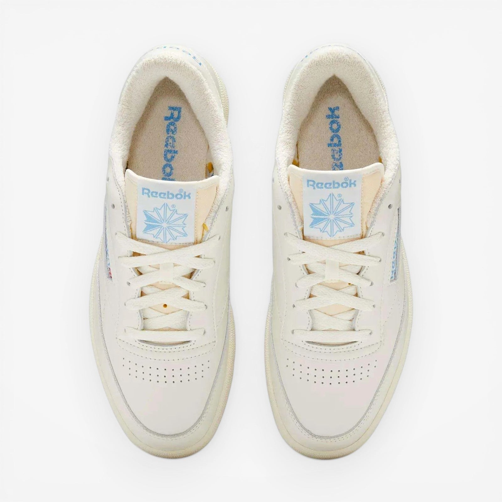 METRO Reebok Club C 85 Vintage low-top sneakers in chalk and essential blue leather with lace-up closure and rubber sole.