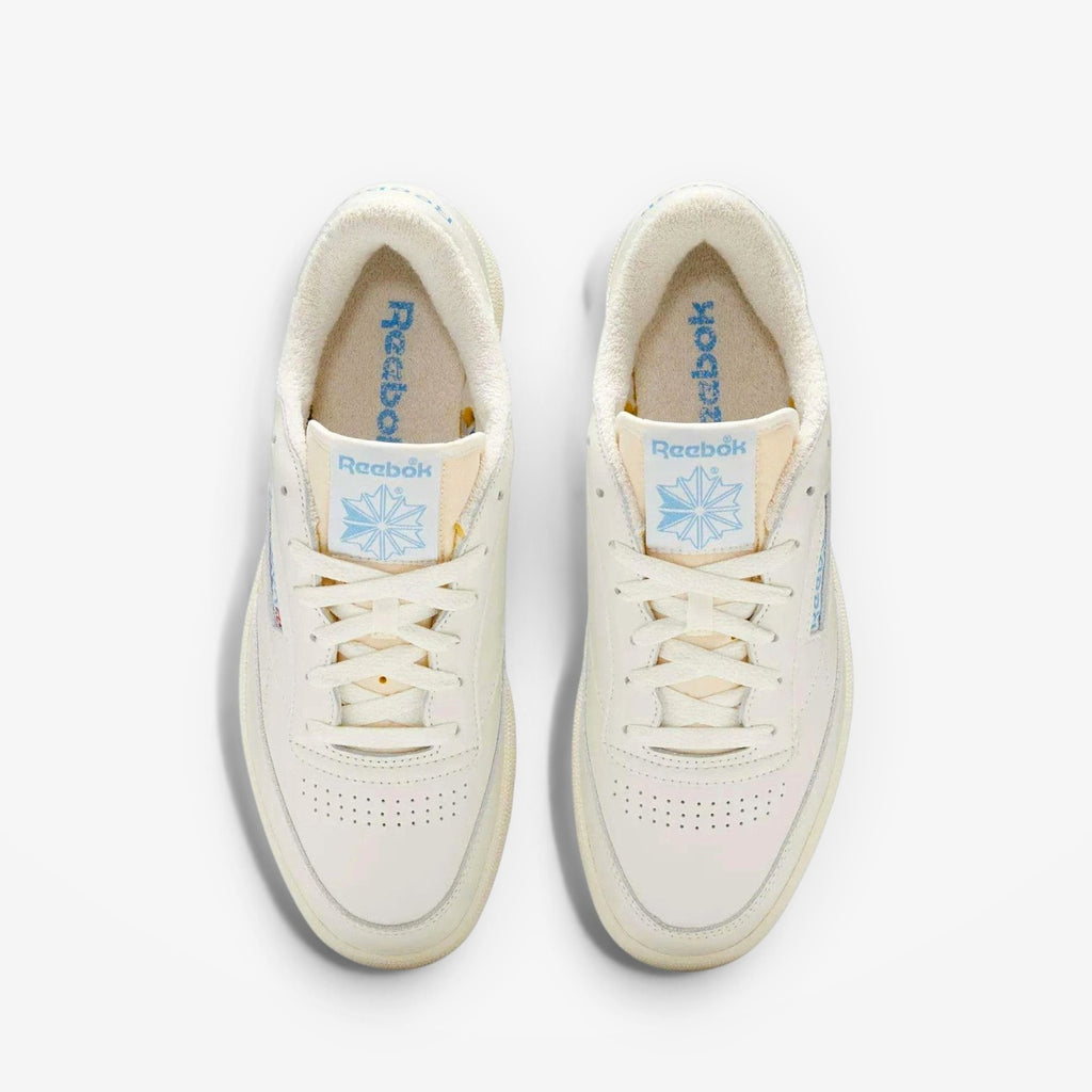 METRO Reebok Club C 85 Vintage low-top sneakers in chalk and essential blue leather with lace-up closure and rubber sole.