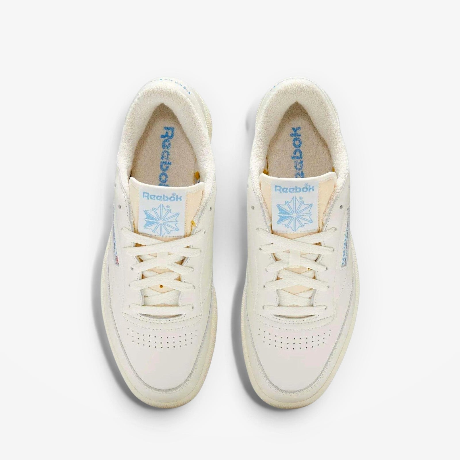 METRO Reebok Club C 85 Vintage low-top sneakers in chalk and essential blue leather with lace-up closure and rubber sole.