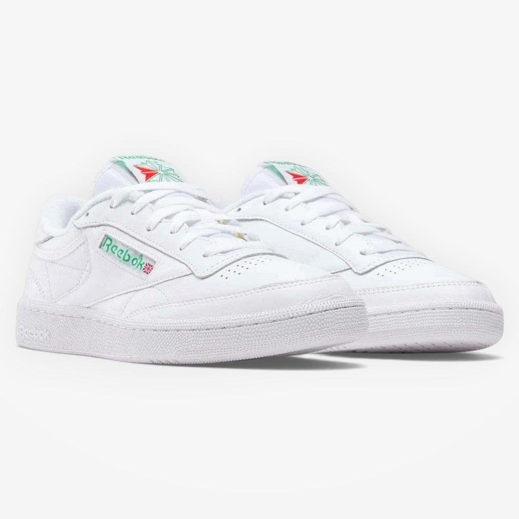 METRO Reebok Club C 85 white leather low-top sneakers with green accents on the logo and heel tab. Lace-up closure.
