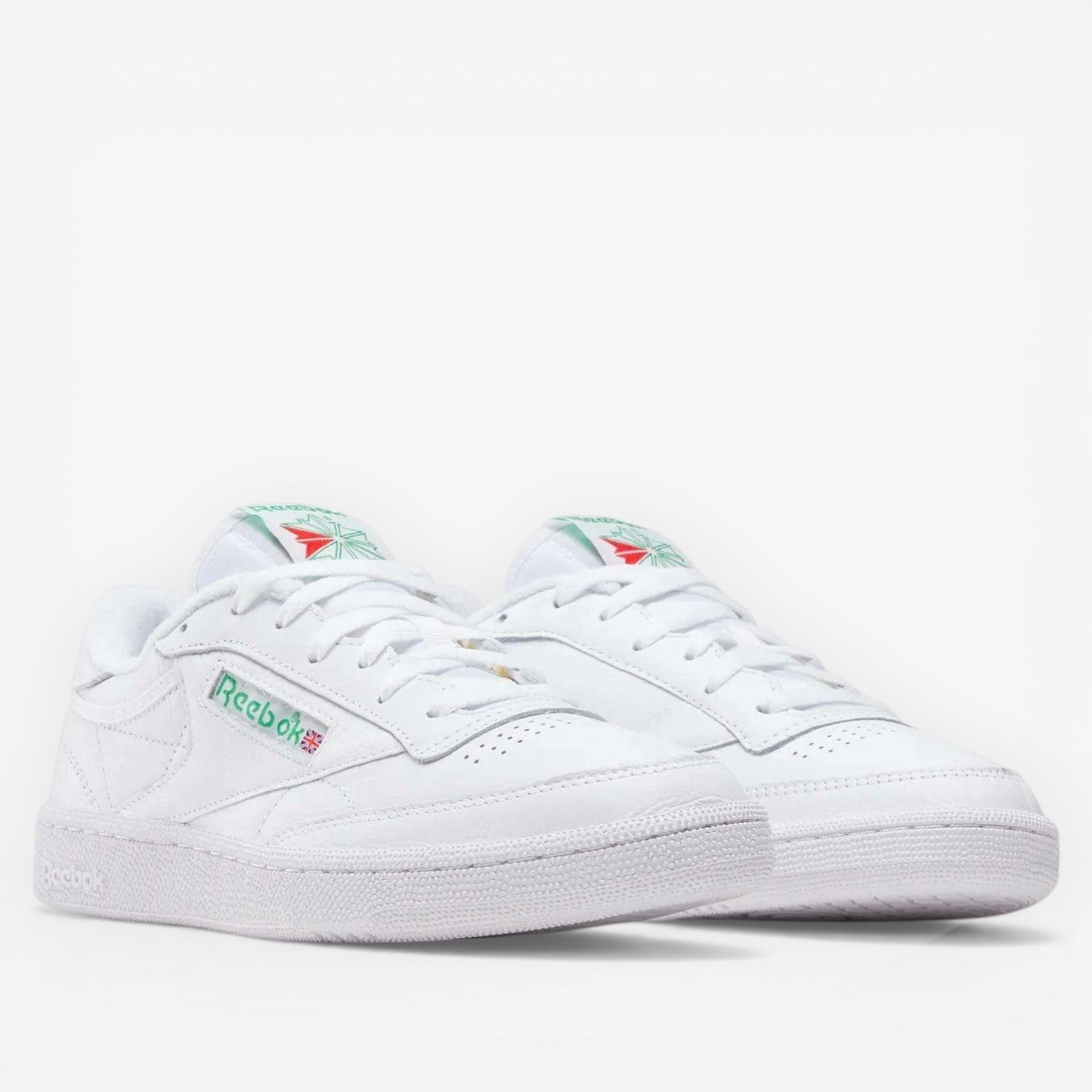 METRO Reebok Club C 85 white leather low-top sneakers with green accents on the logo and heel tab. Lace-up closure.