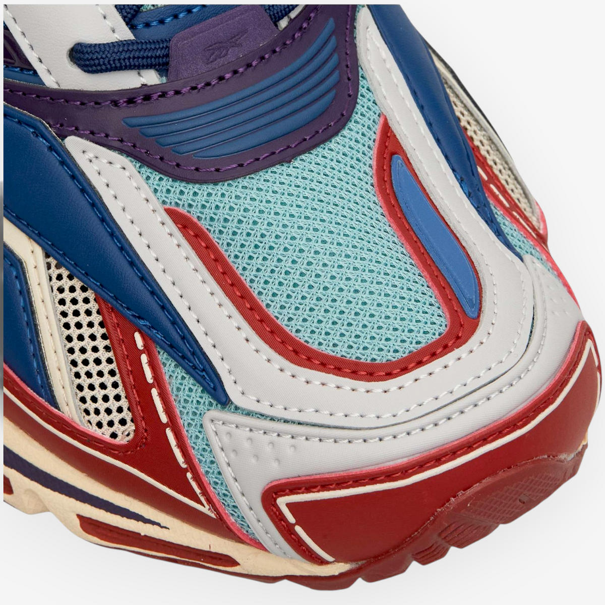 Close-up of Reebok Premier Road Ultra sneaker in red, hazy teal, and white with layered mesh and synthetic panels.