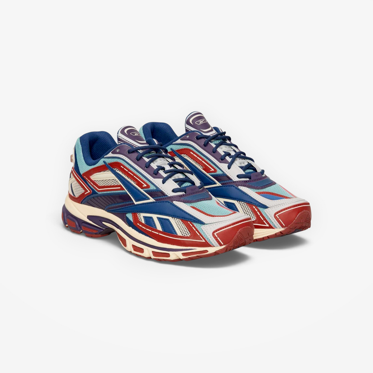Reebok Premier Road Ultra sneakers in red, hazy teal, and paper white with a layered paneled design and chunky midsole.
