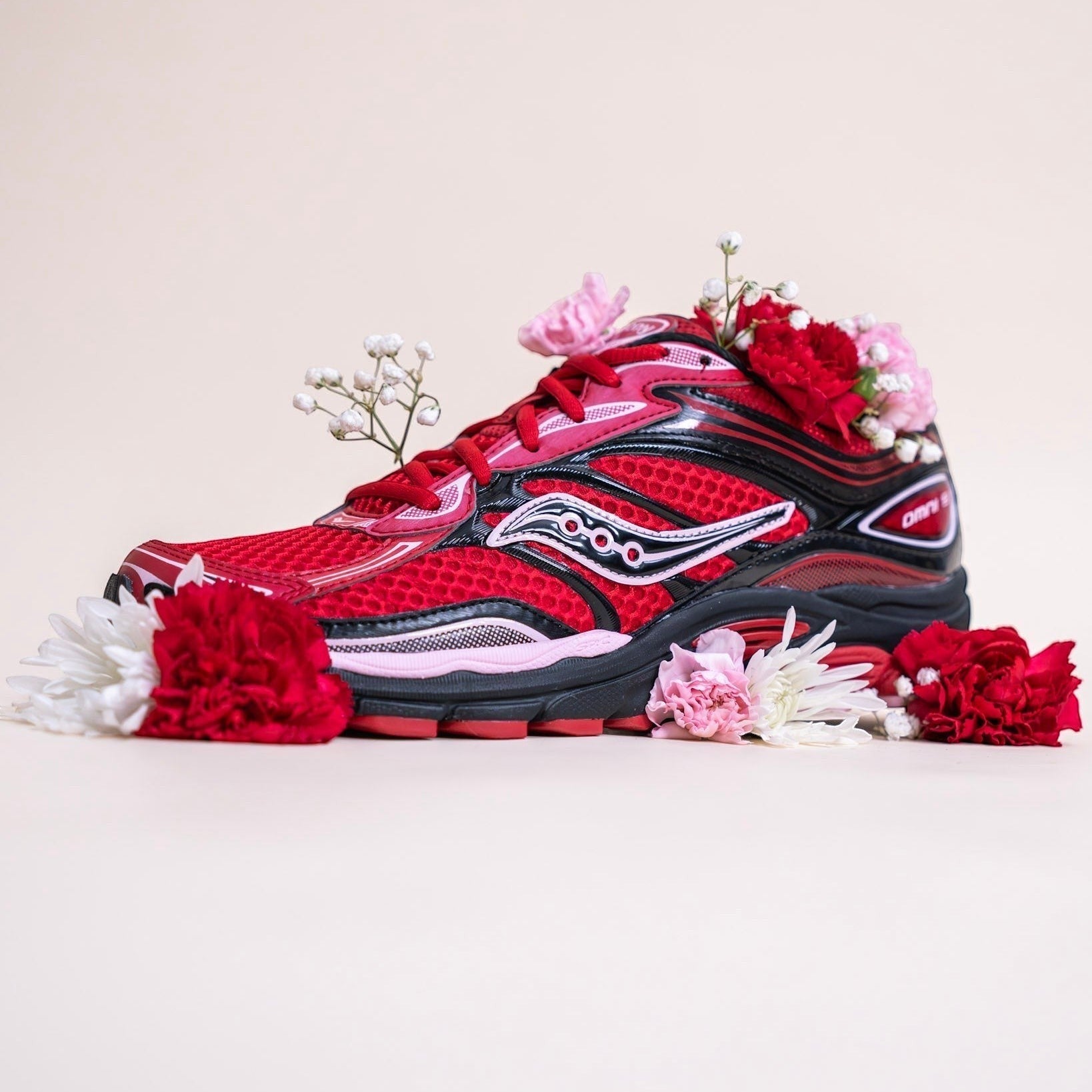 METRO Saucony Omni Grid 9 red running shoe with mesh upper, synthetic overlays, and GRID cushioning.