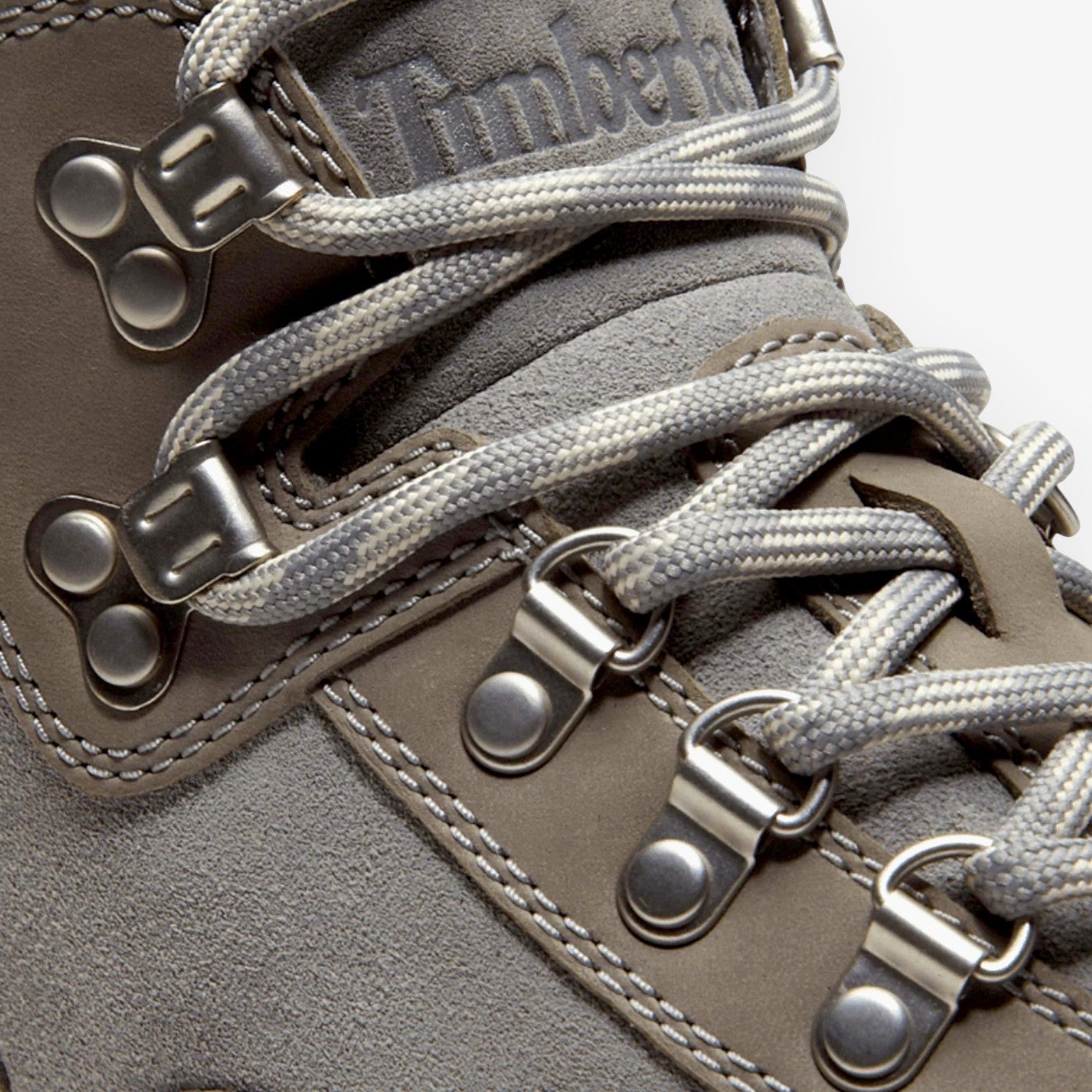 Close-up of METRO Timberland Euro Hiker boots in medium grey suede with metallic D-ring lacing and grey laces
