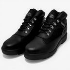 Pair of black leather boots on a light gray background