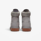 Rear view of METRO Timberland Premium 6-Inch waterproof boots in medium grey nubuck with brown rubber lug soles.