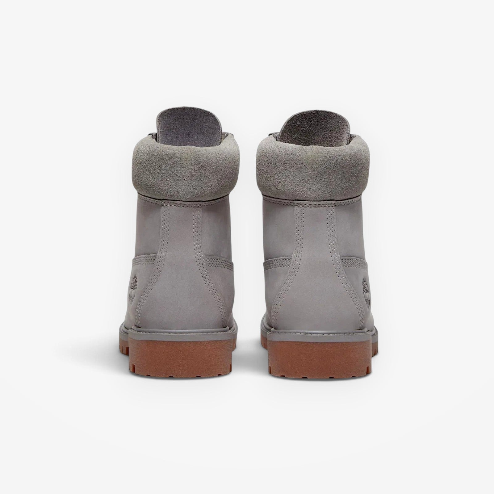 Rear view of METRO Timberland Premium 6-Inch waterproof boots in medium grey nubuck with brown rubber lug soles.