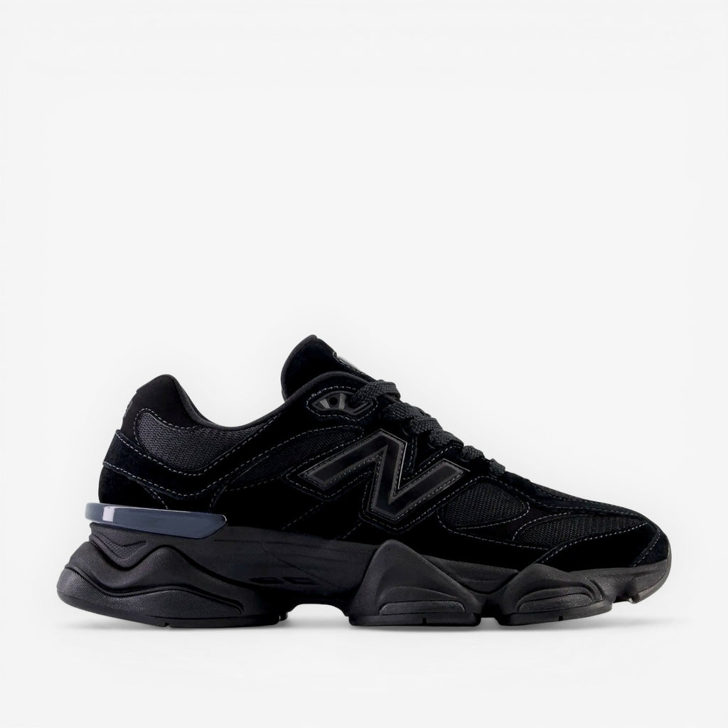 Black New Balance sneaker with chunky sole, mesh and suede details, side logo visible