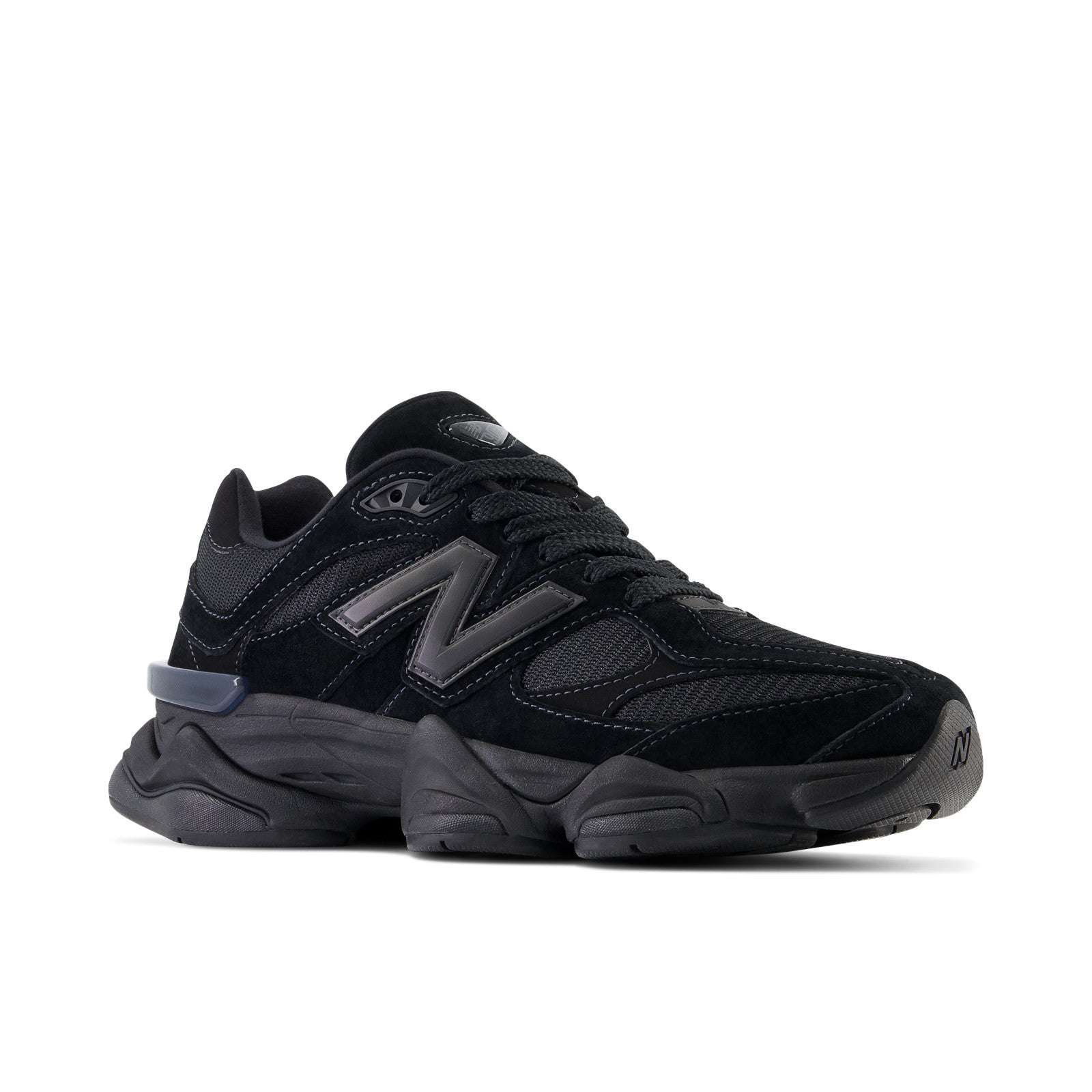 Black New Balance sneaker with chunky sole, mesh and suede panels, side view on white background