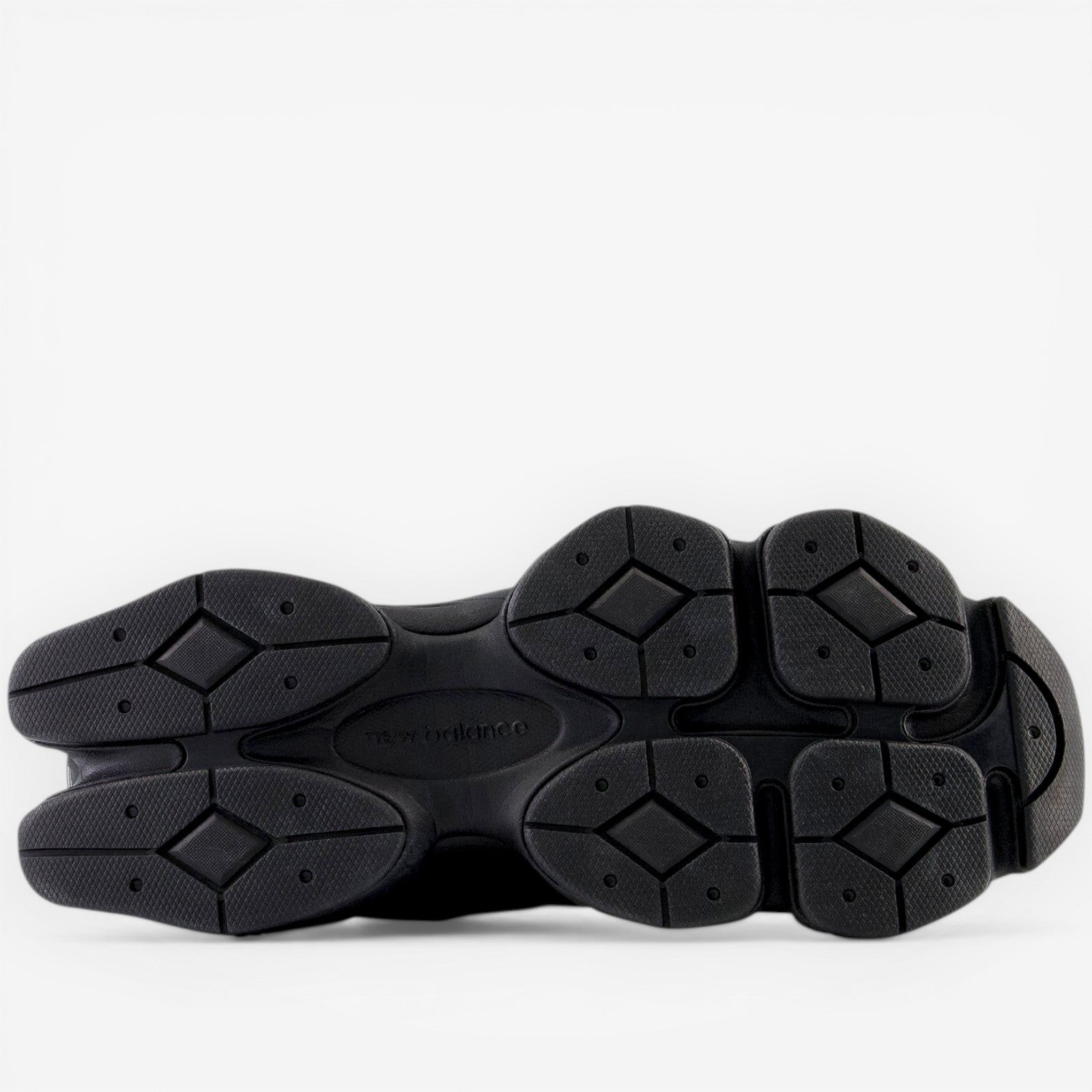 Black New Balance sneaker outsole, textured rubber sole, athletic footwear closeup